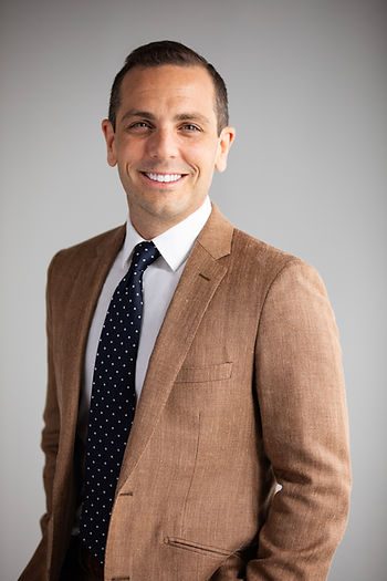 Joseph Rome, LL Law Firm attorney, professional headshot in tan blazer with navy tie