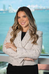 LL Law Firm new attorney, professional headshot in light outfit against Miami skyline